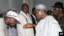 Nigerian President Umaru Yar'Adua (C), flanked by Vice President of Nigeria, Jonathan Goodluck (R), shakes hands with Government Ekpemupolo (L), commander of rebel group MEND, during their meeting in Abuja (File Photo)