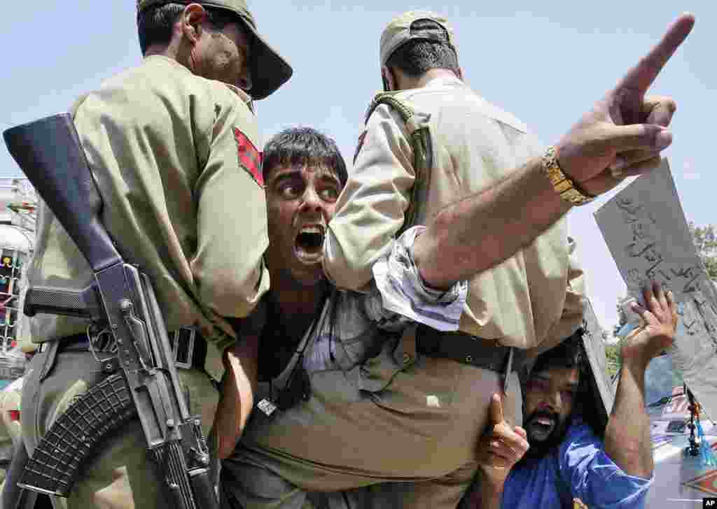 Pengunjuk rasa Kashmir meneriakkan slogan menentang Israel dari dalam kendaraan polisi setelah mereka ditahan saat demonstrasi di Srinagar, India, 14 Juli 2014.