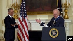 El presidente Obama sonríe mientras escucha el agradecimiento del vicepresidente Joe Biden por haberle otorgado la Medalla Presidencial de la Libertad.