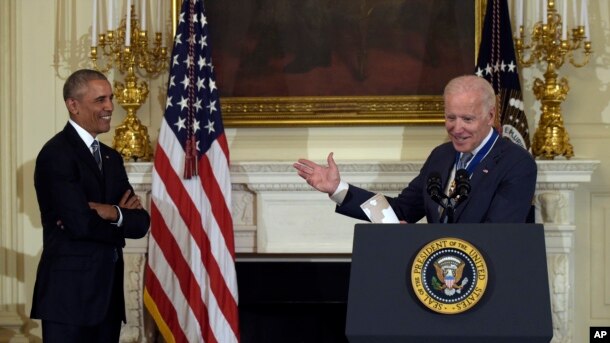 El presidente Obama sonríe mientras escucha el agradecimiento del vicepresidente Joe Biden por haberle otorgado la Medalla Presidencial de la Libertad.