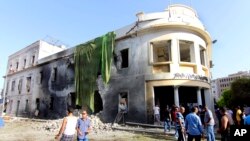 People gather to look at the site of a car bombing in Benghazi, Libya, September 11, 2013. 