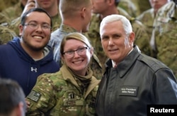 U.S. Vice President Mike Pence poses for photos with troops in a hangar at Bagram Air Field in Afghanistan, Dec. 21, 2017.