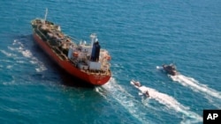 FILE - In this Jan. 4, 2021, photo, released by Tasnim News Agency, a seized South Korean-flagged tanker, is escorted by Iranian Revolutionary Guard boats on the Persian Gulf.