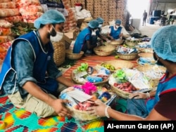 Members of Bidyanondo Foundation pack packages for distribution to COVID-19 patients in Dhaka, Bangladesh, June 6, 2020.