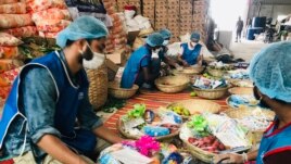 Members of Bidyanondo Foundation pack packages for distribution to COVID-19 patients in Dhaka, Bangladesh, June 6, 2020.