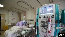 ဝူဟန်မြို့ ဆေးရုံတွင် ကိုရိုနာဗိုင်းရပ်စ် ကူးစက်ခံ လူနာတဦးအား ပြုစုကုသနေသည့် ကျန်းမာရေးဝန်ထမ်းတဦး။ (ဖေဖော်ဝါရီ ၂၈၊ ၂၀၂၀)