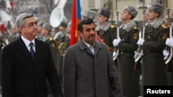 Armenian President Serzh Sargsyan (L) walks with Iran's President Mahmoud Ahmadinejad (C) during an official welcoming ceremony in Yerevan, Dec. 23, 2011. 