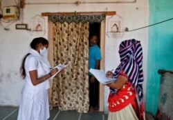 Health workers collect personal data during a door-to-door survey for the first shot of COVID-19 vaccine for people above 50 years of age and those with comorbidities, in a village on the outskirts of Ahmedabad, India, Dec. 14, 2020.