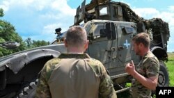 资料照片：乌克兰第37海军陆战旅一名代号“斯巴达”的营长(左)在顿涅茨克前线附近与一名海军陆战队员交谈。(2023年6月30日)