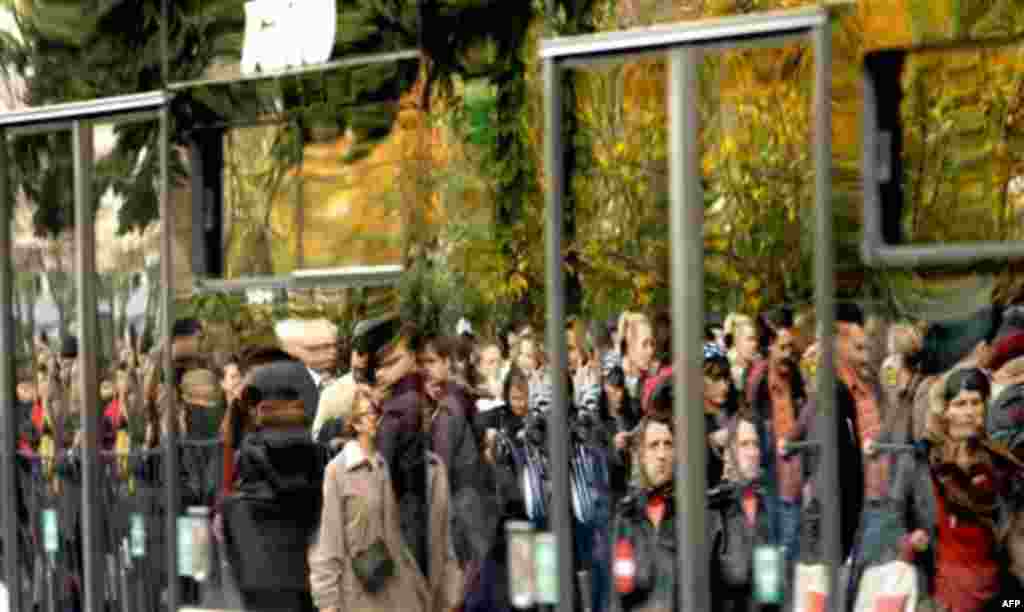 Romanian Orthodox worshippers are reflected in a bus window, as they wait in long lines to touch the remains of Saint Mina or Menas, in Bucharest, Romania, Thursday, Nov. 11, 2010. Thousands wait long hours to touch the remains of the saint who, according