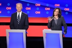 Democratic presidential hopeful U.S. Senator from California Kamala Harris, right, delivers her closing statement flanked by former Vice President Joe Biden in the Democratic primary debate hosted by CNN at the Fox Theatre in Detroit, July 31, 2019.