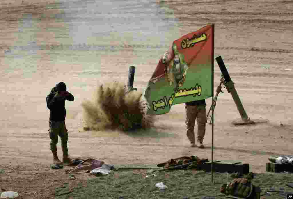 Iraqi army soldiers fire mortar shells during their battle against the Islamic State group, in the front-line village of Haj Ali, southern Mosul.