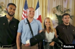 FILE - U.S. ambassador to France Jane Hartley (2nd R) presents student Anthony Sadler (L), U.S Airman First Class Spencer Stone (2nd L) and National Guardsman Alek Skarlatos (R) as they attend a ceremony at the U.S. Embassy in Paris, France, Aug. 23, 2015.