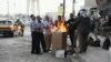 伊拉克失业劳工一大早在巴格达街头烤火取暖，等待有人聘用他们做短工。