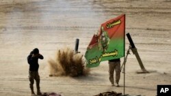 Iraqi army soldiers, fire mortar shells during their battle against the Islamic State group, in Haj Ali front line village, southern Mosul, Iraq, Nov. 29, 2016. 