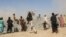 Residents gather as a rescue helicopter with medical supplies lands following an earthquake in Harnai, Balochistan, Pakistan, October 7, 2021. 