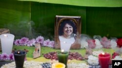 FILE - A framed image of environmentalist Berta Caceres on a makeshift altar made in her honor during a demonstration outside Honduras' embassy, in Mexico City, June 15, 2016. 