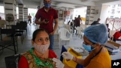 An Indian woman gets inoculated against COVID—19 at a vaccination center in Ahmedabad, India, Friday, July 30, 2021. (AP Photo/Ajit Solanki)