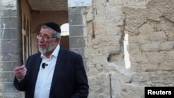 Joseph Hamra, a Syrian Jewish rabbi who left Syria years ago, talks in front of the destroyed synagogue in Jobar, on the outskirts of Damascus, Syria, Feb. 18, 2025.