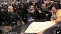 Egyptian Christians cheer as they put a piece of paper that reads 'we don't need Habib El-Adly, Minister of the Interior' on a car driven by a Christian during clashes with riot police outside al-Abasseya Cathedral in Cairo late night, 02 Jan 2011.