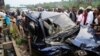 People look at the wreckage of a car following a road accident in Kinshasa, on February 16, 