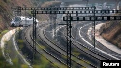 Mesin kereta api naas masih teronggok di sisi rel kereta api pasca kecelakaan di dekat kota Santiago de Compostela, Spanyol Utara (26/7).