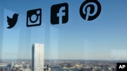 纽约的一面窗户上显示了四大社交媒体的图标，左起：推特，Instagram，脸书和Pinterest
