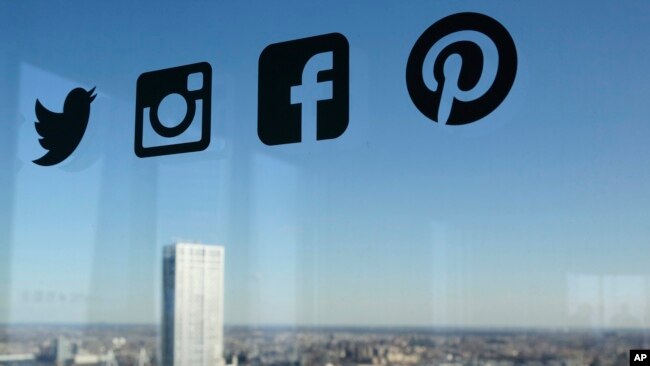 资料照：一扇玻璃窗上显示的推特、脸书等社交媒体的标识。