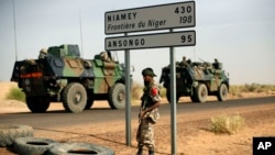 FILE - French armored vehicles heading towards the Niger border before making a left turn north in Gao, northern Mali.