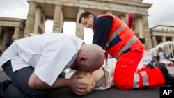 Paramedics demonstrate how to apply CPR on a dummy in front of Brandenburg Gate in Berlin.
