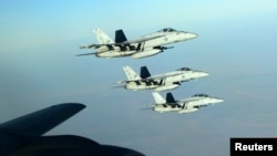 A formation of U.S. Navy F-18E Super Hornets leaves after receiving fuel from a KC-135 Stratotanker over northern Iraq on September 23, 2014. These aircraft were part of a large coalition strike package that was the first to strike ISIL targets in Syria. 
