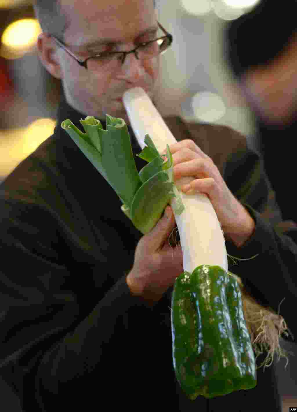Seorang musisi memainkan musik secara eksklusif dengan instrumen sayuran (wortel dan mentimun) sebelum konser untuk peringatan 100 tahun pasar San Miguel di kota Madrid, Spanyol. 