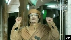 This image broadcast on Libyan state television Tuesday, Feb. 22, 2011, shows Libyan leader Moammar Gadhafi as he addresses the nation in Tripoli, Libya. Libya's Gadhafi vowed to fight on against protesters demanding his ouster and die as martyr. (AP Phot
