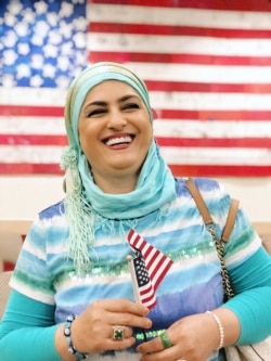 This September 2019 provided by Danielle Luna shows Iraqi born refugee Nada Al Rubaye at her naturalization ceremony in Phoenix. The artist left Baghdad after one of her sons and several other relatives were killed in the widespread violence.