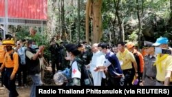 Seorang biksu Thailand berjalan dengan petugas penyelamat setelah mereka diselamatkan dari gua Phra Sai Ngam, Provinsi Noen Maprang, Thailand, 7 April 2021 dalam gambar yang diperoleh dari video media sosial. (Foto: Radio Thailand Phitsanulok via REUTERS)