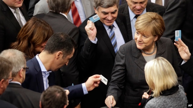 La canciller alemana Angela Merkel, a la derecha, vota este viernes en el parlamento de su país, en Berlin, Germany, Dec.4, 2015.  