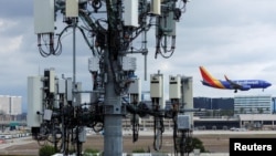 A Southwest commercial aircraft flies past a cellphone tower as it approaches to land at John Wayne Airport in Santa Ana, California, Jan. 18, 2022. 