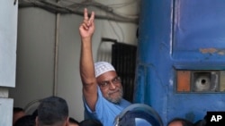 Mir Quashem Ali, pemimpin senior partai Islam terbesar Bangladesh Jamaat-e-Islami mengacungkan tanda kemenangan ketika memasuki mobil polisi setelah pengadilan menjatuhkan hukuman mati di Dhaka, Bangladesh, 2 November 2014.