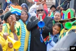 ANC mayor of Port Elizabeth Zanoxolo Wayile, center, blows a trumpet before the 2010 soccer World Cup… The DA blames costs associated with the tournament for a financial crisis in the city