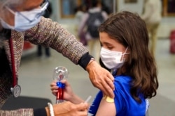 Jehna Kottori (10) dari Worcester, Mass., disuntik vaksin Pfizer COVID-19, di klinik vaksinasi keliling, di Worcester, 2 Desember 2021.