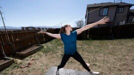 FILE - In this April 29, 2020, file photo, Olympic javelin thrower Kara Winger uses a cable system to simulate throwing a javelin as she trains outside her home in Colorado Springs, Colo.