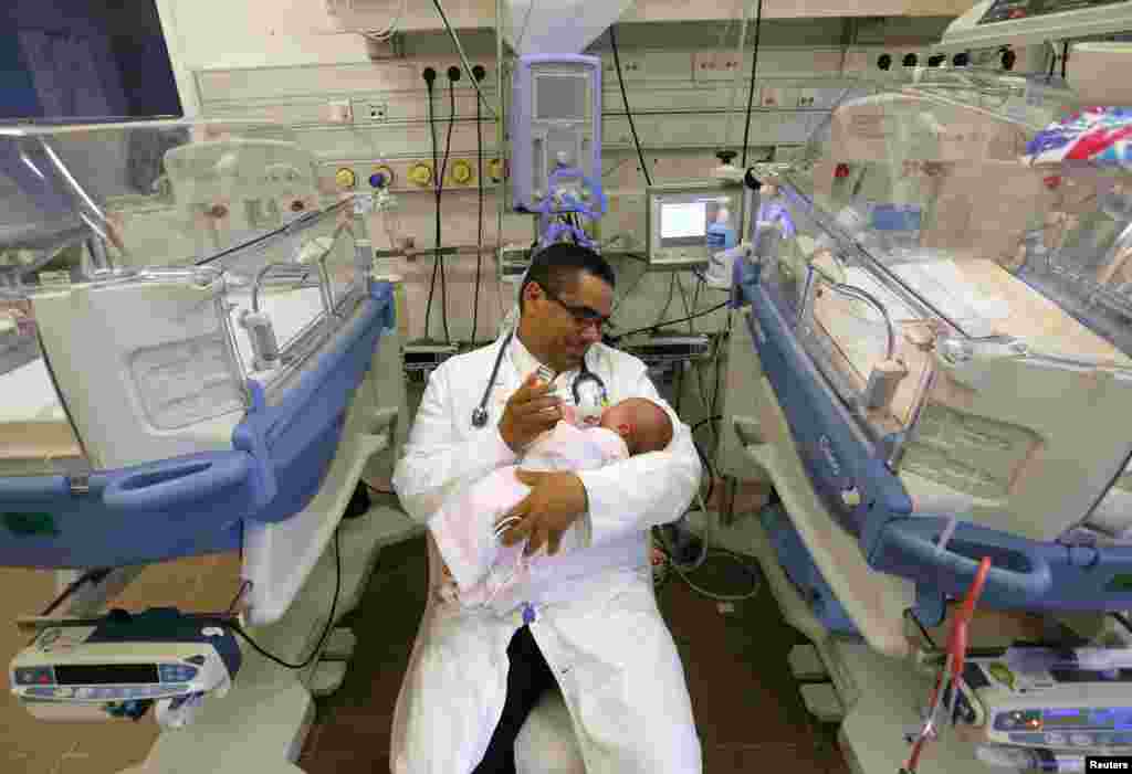 Mohamed Abdulrahman Abdulrab, a Yemeni-born Hungarian doctor who was voted "Doctor of the Year" by Hungarian patients for his dedication, holds a new born baby at the hospital in Gyula, March 23, 2016.