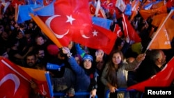 Women wave flags celebrating the AK Party's lead in Sunday's parliamentary elections outside party headquarters in Ankara, Turkey, November 1, 2015.