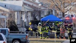 Oficiales de la policía y los bomberos examinan el sitio donde cayó un avión privado, cerca del aeropuerto regional de South Bend, en Indiana.