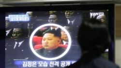 A worker in Paju, South Korea, looks at a picture of North Korea's Kim Jong Un on a TV news show. Experts say Kim Jong Il could be preparing his third and youngest son for leadership.