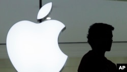 FILE - A person stands near the Apple logo at the company's store in Grand Central Terminal, in New York, Dec. 7, 2011. Apple appears poised to unveil a voice-activated, internet-connected speaker that would create a new digital pipeline into people’s hom