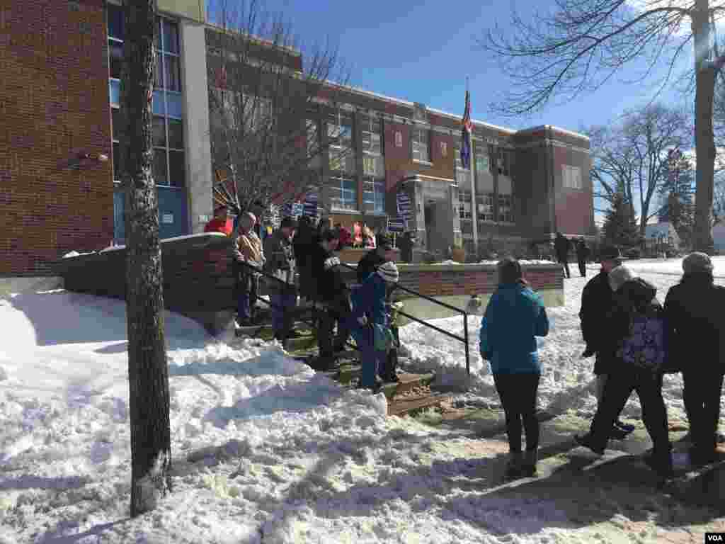 Orang-orang masuk dan keluar TPS di Ward 1, Manchester, New Hampshire, 9 Februari 2016. (Foto: K. Gypson / VOA)