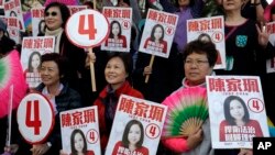 Supporters of Hong Kong pro-Beijing by-election candidate Judy Chan hold a portrait of Chan during an election campaign in Hong Kong, March 9, 2018.