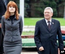 Maria Butina walks with Alexander Torshin then a member of the Russian upper house of parliament in Moscow, Russia, Sept. 7, 2012.
