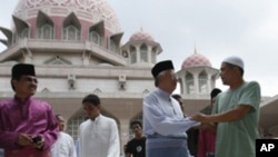 Malaysia's Prime Minister Najib Razak (2nd R) meets people after Friday prayers at the Putra Mosque in Putrajaya outside Kuala Lumpur, 10 Jul 2010